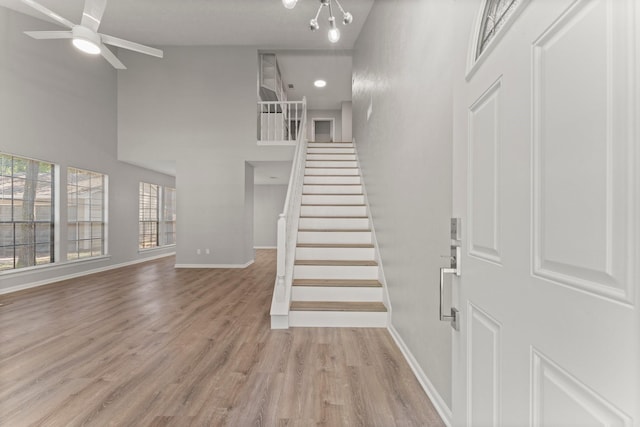 235 E Rainbow Ridge Cir, The Woodlands, TX 77381 - foyer with stairs, light wood finished floors, ceiling fan, high vaulted ceiling, and a chandelier