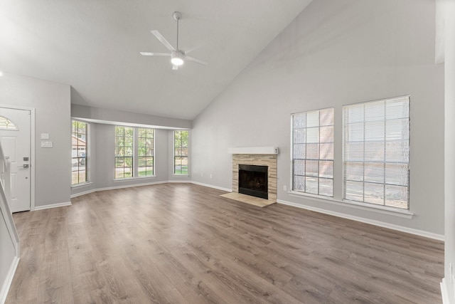 235 E Rainbow Ridge Cir, The Woodlands, TX 77381 - unfurnished living room with high vaulted ceiling, ceiling fan, a fireplace, and wood finished floors