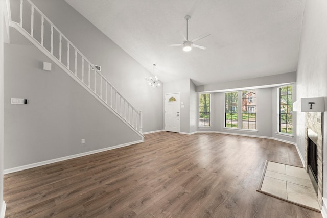 235 E Rainbow Ridge Cir, The Woodlands, TX 77381 - unfurnished living room with a fireplace, a ceiling fan, stairway, wood finished floors, and a chandelier