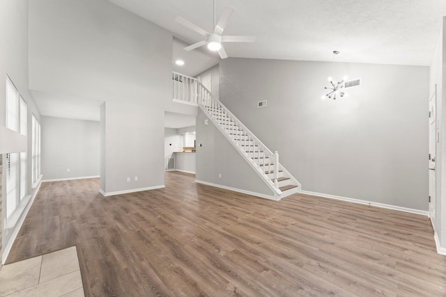 235 E Rainbow Ridge Cir, The Woodlands, TX 77381 - unfurnished living room featuring high vaulted ceiling, stairway, a ceiling fan, wood finished floors, and a chandelier