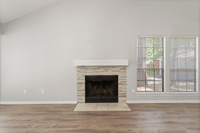 235 E Rainbow Ridge Cir, The Woodlands, TX 77381 - unfurnished living room featuring wood finished floors, high vaulted ceiling, and a fireplace