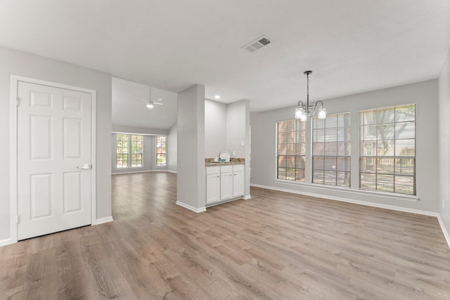 235 E Rainbow Ridge Cir, The Woodlands, TX 77381 - unfurnished living room with a chandelier, light wood-type flooring, and recessed lighting