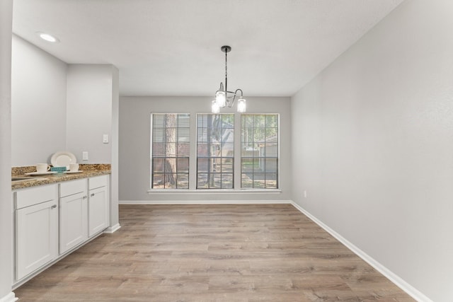 235 E Rainbow Ridge Cir, The Woodlands, TX 77381 - unfurnished dining area featuring a chandelier, light wood-style flooring, and recessed lighting