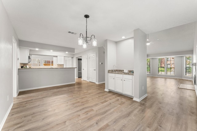 235 E Rainbow Ridge Cir, The Woodlands, TX 77381 - unfurnished living room featuring light wood-type flooring, a chandelier, ceiling fan, and recessed lighting
