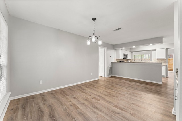 235 E Rainbow Ridge Cir, The Woodlands, TX 77381 - unfurnished living room with light wood-type flooring