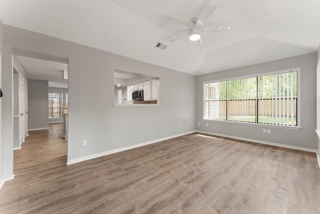 235 E Rainbow Ridge Cir, The Woodlands, TX 77381 - spare room with light wood-style floors, a ceiling fan, and lofted ceiling