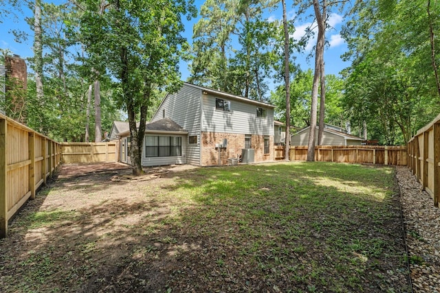235 E Rainbow Ridge Cir, The Woodlands, TX 77381 - rear view of house with brick siding and a fenced backyard