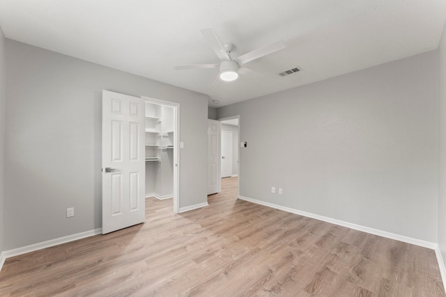 235 E Rainbow Ridge Cir, The Woodlands, TX 77381 - unfurnished bedroom featuring light wood finished floors, a walk in closet, and a closet