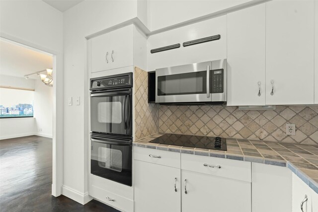 5000 Montrose Blvd Unit 15C, Houston, TX 77006 - kitchen with black appliances, tile counters, decorative backsplash, and white cabinets