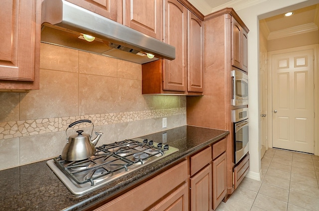2918 Royal Oaks Grn, Houston, TX 77082 - kitchen with under cabinet range hood, stainless steel appliances, ornamental molding, light tile patterned floors, and decorative backsplash