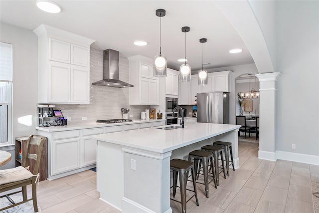 271 Bronze View Dr, Montgomery, TX 77316 - kitchen with stainless steel appliances, wall chimney exhaust hood, a sink, arched walkways, and decorative backsplash