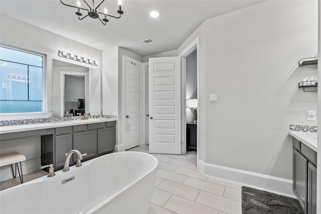 271 Bronze View Dr, Montgomery, TX 77316 - bathroom featuring vanity, a soaking tub, a chandelier, and baseboards