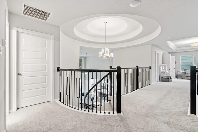 271 Bronze View Dr, Montgomery, TX 77316 - hallway featuring a chandelier, carpet floors, a tray ceiling, and an upstairs landing