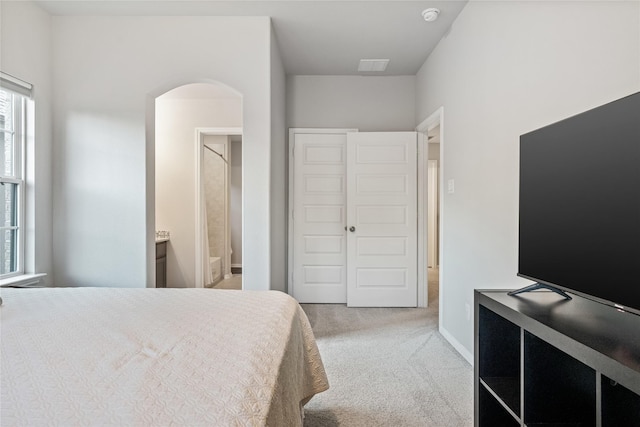 271 Bronze View Dr, Montgomery, TX 77316 - carpeted bedroom featuring arched walkways, connected bathroom, and baseboards