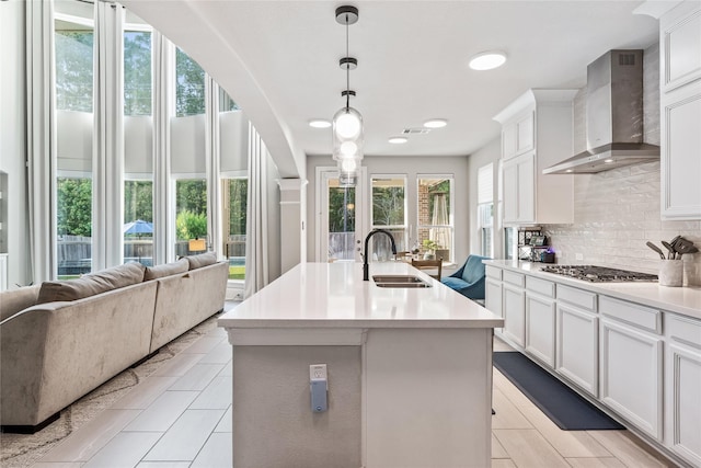 271 Bronze View Dr, Montgomery, TX 77316 - kitchen with a sink, wall chimney exhaust hood, decorative backsplash, light countertops, and white cabinetry