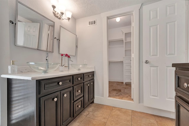 615 Allston St, Houston, TX 77007 - full bath featuring double vanity, a textured ceiling, and tile patterned flooring