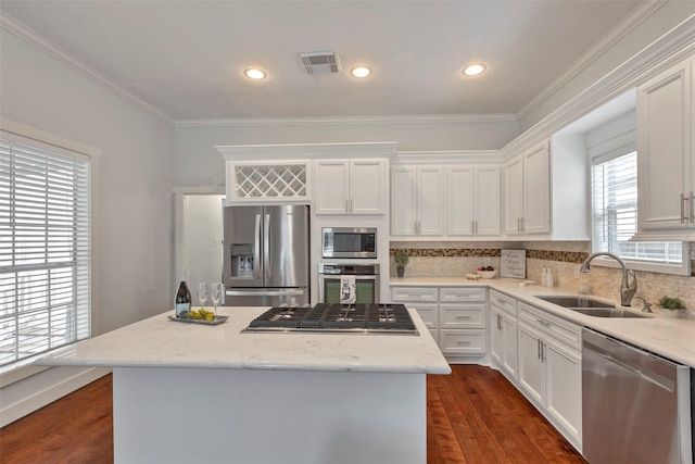 615 Allston St, Houston, TX 77007 - kitchen featuring stainless steel appliances, a sink, a center island, backsplash, and white cabinetry