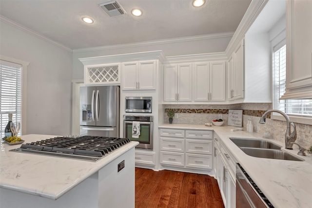 615 Allston St, Houston, TX 77007 - kitchen with appliances with stainless steel finishes, a sink, white cabinetry, decorative backsplash, and ornamental molding