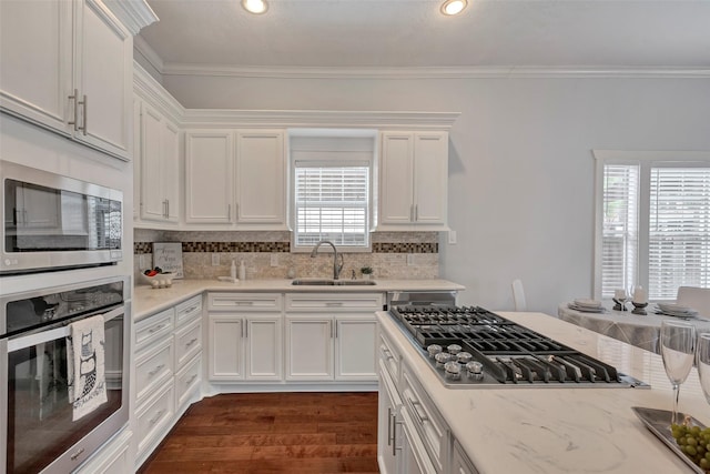 615 Allston St, Houston, TX 77007 - kitchen featuring a sink, stainless steel appliances, white cabinets, tasteful backsplash, and crown molding