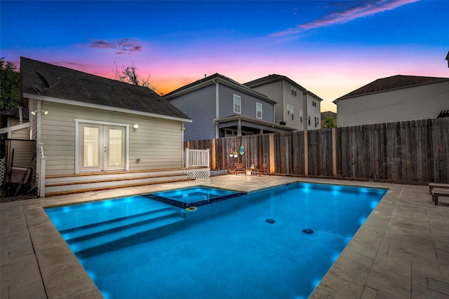 615 Allston St, Houston, TX 77007 - pool at dusk with a fenced backyard, a pool with connected hot tub, a patio, and an outbuilding