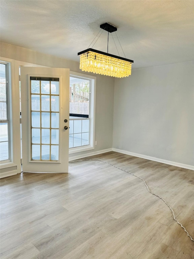 312 Bridal Wreath Ave, Orange, TX 77630 - unfurnished dining area featuring a chandelier, wood finished floors, baseboards, and a textured ceiling