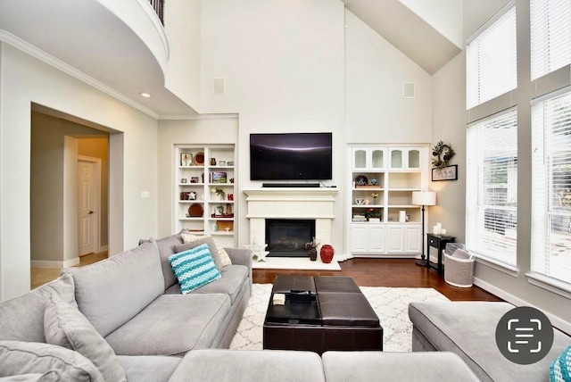 6002 Shady Birch Holw, Kingwood, TX 77345 - living area with high vaulted ceiling, crown molding, dark wood-type flooring, a glass covered fireplace, and built in features