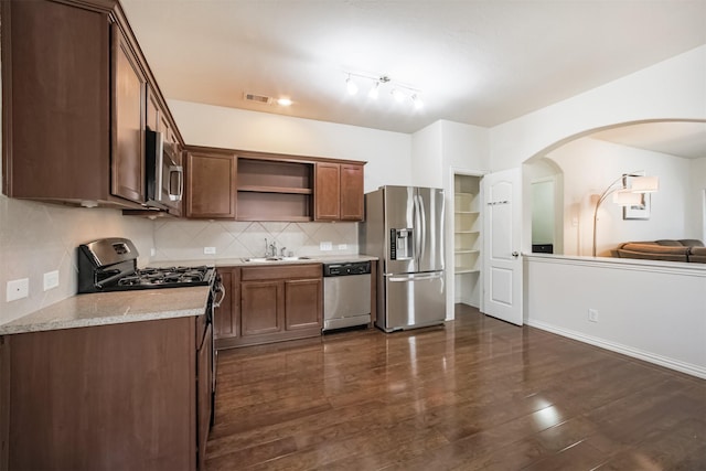 9609 Landon Lake Dr, Pearland, TX 77584 - kitchen featuring stainless steel appliances, open shelves, arched walkways, a sink, and dark wood finished floors