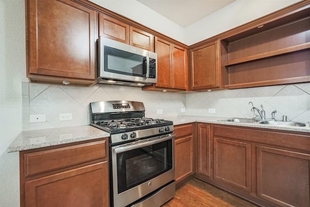 9609 Landon Lake Dr, Pearland, TX 77584 - kitchen featuring stainless steel appliances, open shelves, a sink, decorative backsplash, and light stone counters