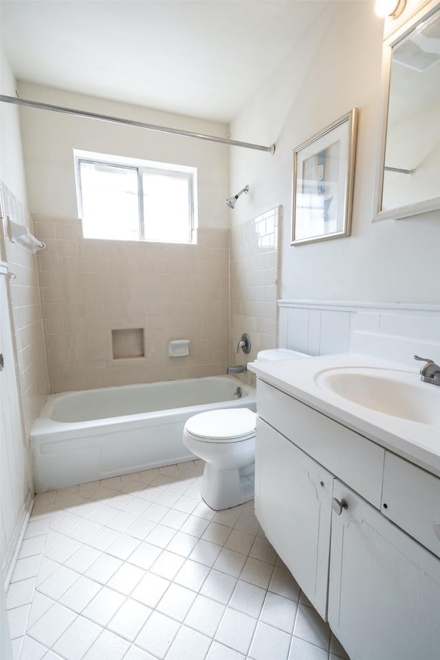 7613 Parker Rd, Houston, TX 77016 - bathroom featuring vanity, shower / tub combination, toilet, tile patterned floors, and wainscoting