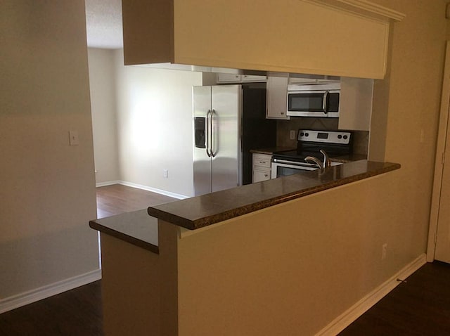 5 Lazybrook St, Angleton, TX 77515 - kitchen with appliances with stainless steel finishes, dark countertops, dark wood-style floors, and baseboards