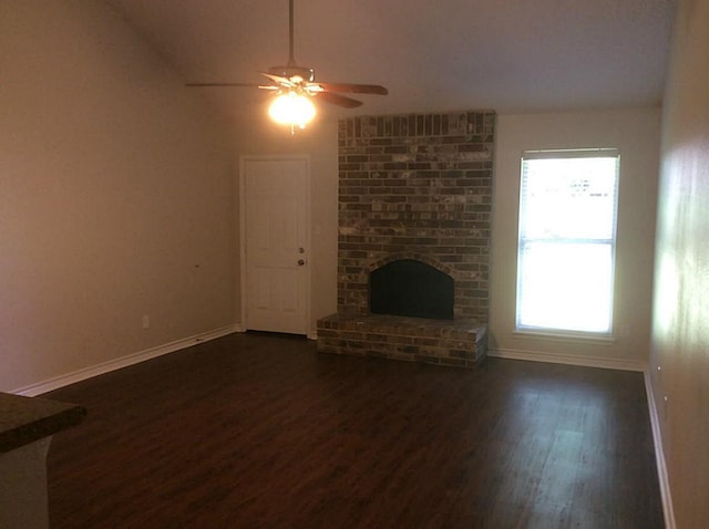 5 Lazybrook St, Angleton, TX 77515 - unfurnished living room with dark wood finished floors, ceiling fan, baseboards, a brick fireplace, and lofted ceiling