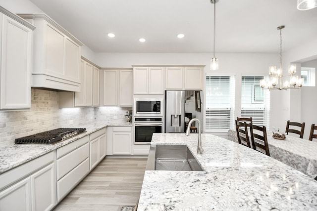 18511 Adventurous Way, Cypress, TX 77433 - kitchen featuring appliances with stainless steel finishes, a sink, decorative backsplash, light wood-style flooring, and recessed lighting