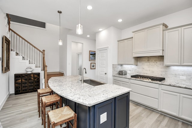 18511 Adventurous Way, Cypress, TX 77433 - kitchen featuring stainless steel gas cooktop, a sink, light wood-style floors, tasteful backsplash, and recessed lighting