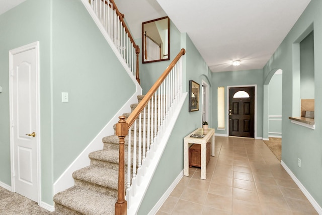 11401 Starlight Bay St, Pearland, TX 77584 - foyer with light tile patterned floors, stairway, baseboards, and arched walkways