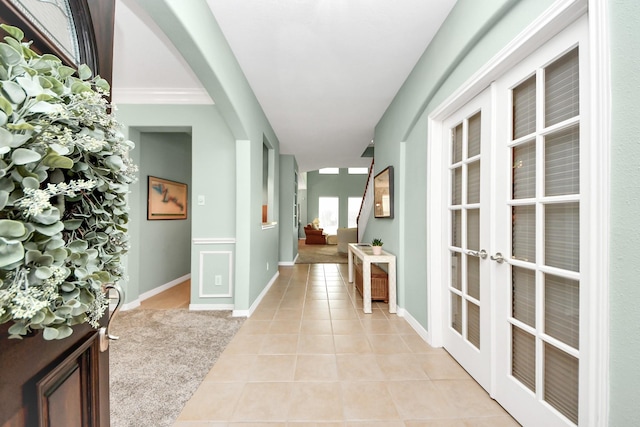 11401 Starlight Bay St, Pearland, TX 77584 - hallway featuring light tile patterned floors, french doors, arched walkways, and baseboards
