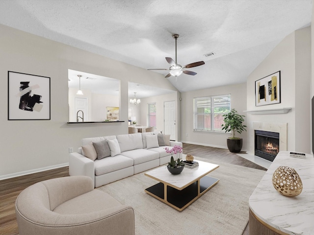 27097 Crown Chase Dr, Kingwood, TX 77339 - living room featuring wood finished floors, baseboards, vaulted ceiling, a ceiling fan, and a high end fireplace