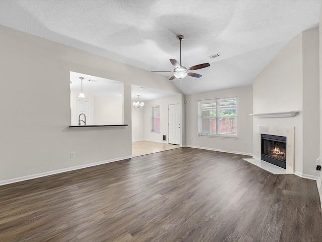 27097 Crown Chase Dr, Kingwood, TX 77339 - unfurnished living room featuring a ceiling fan, a high end fireplace, wood finished floors, lofted ceiling, and a chandelier