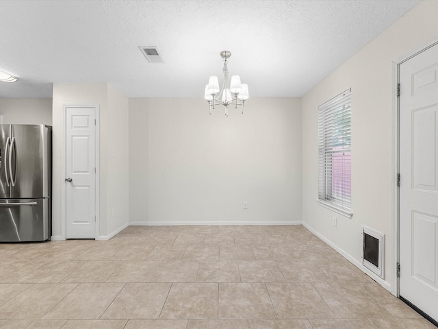 27097 Crown Chase Dr, Kingwood, TX 77339 - unfurnished dining area featuring a chandelier, light tile patterned flooring, baseboards, and a textured ceiling