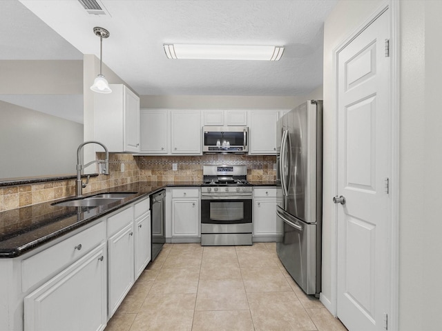 27097 Crown Chase Dr, Kingwood, TX 77339 - kitchen featuring appliances with stainless steel finishes, a sink, tasteful backsplash, and white cabinetry