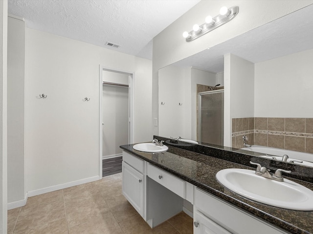 27097 Crown Chase Dr, Kingwood, TX 77339 - full bath featuring a stall shower, a walk in closet, a garden tub, double vanity, and a textured ceiling