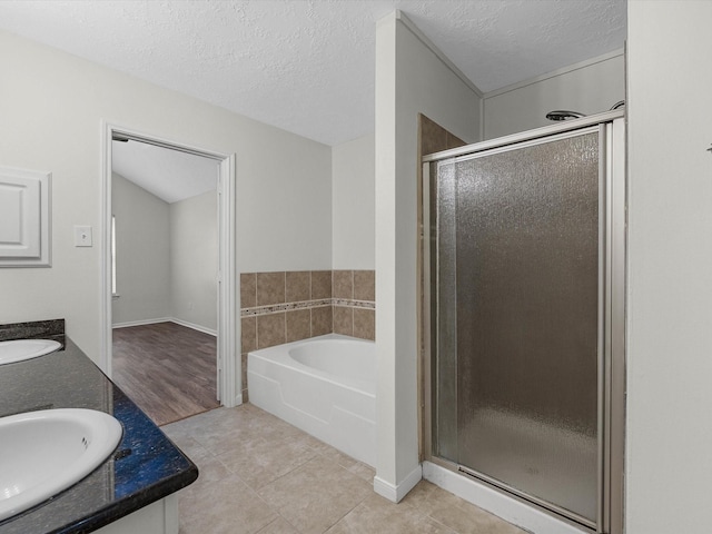 27097 Crown Chase Dr, Kingwood, TX 77339 - full bathroom with a garden tub, a shower stall, double vanity, tile patterned flooring, and a textured ceiling