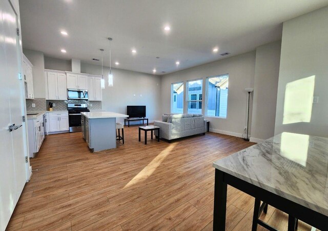 615 Northew St Unit J, Houston, TX 77091 - living area with light wood finished floors, recessed lighting, and baseboards
