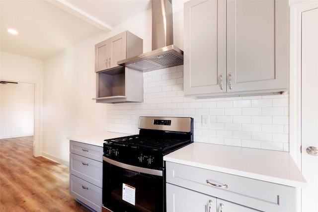 601 S Carroll St, La Porte, TX 77571 - kitchen with range with gas cooktop, wall chimney exhaust hood, gray cabinetry, and backsplash