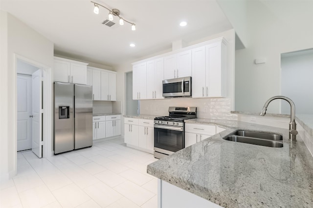 10618 Bassoon Dr, Houston, TX 77025 - kitchen with appliances with stainless steel finishes, a sink, light stone countertops, decorative backsplash, and white cabinets