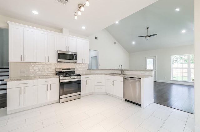 10618 Bassoon Dr, Houston, TX 77025 - kitchen featuring stainless steel appliances, a sink, a peninsula, light stone countertops, and tasteful backsplash