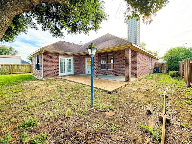 4906 Arbor Falls Ln, Houston, TX 77084 - rear view of house featuring french doors, brick siding, a chimney, and a patio area