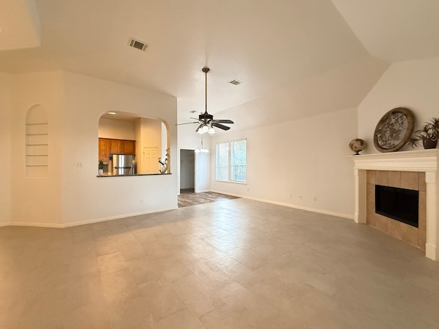 4906 Arbor Falls Ln, Houston, TX 77084 - unfurnished living room with ceiling fan, a fireplace, baseboards, vaulted ceiling, and arched walkways