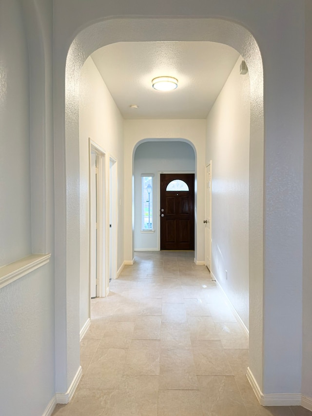 4906 Arbor Falls Ln, Houston, TX 77084 - hallway featuring arched walkways, baseboards, and a textured wall