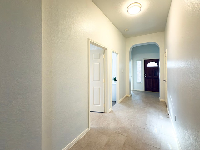 4906 Arbor Falls Ln, Houston, TX 77084 - hallway with arched walkways, a textured wall, and baseboards
