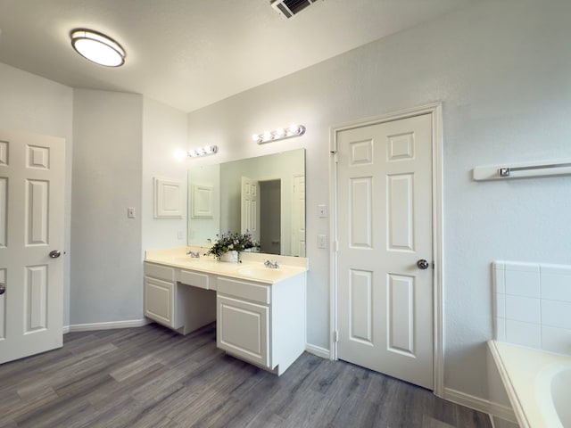 4906 Arbor Falls Ln, Houston, TX 77084 - full bath featuring wood finished floors, a garden tub, double vanity, and baseboards